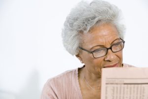 Retired Lady reading about investment owning stocks in retirement